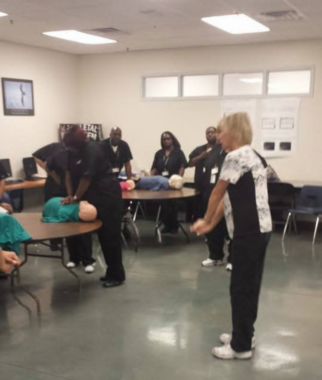 Instructor supervising CPR skills practice with healthcare students