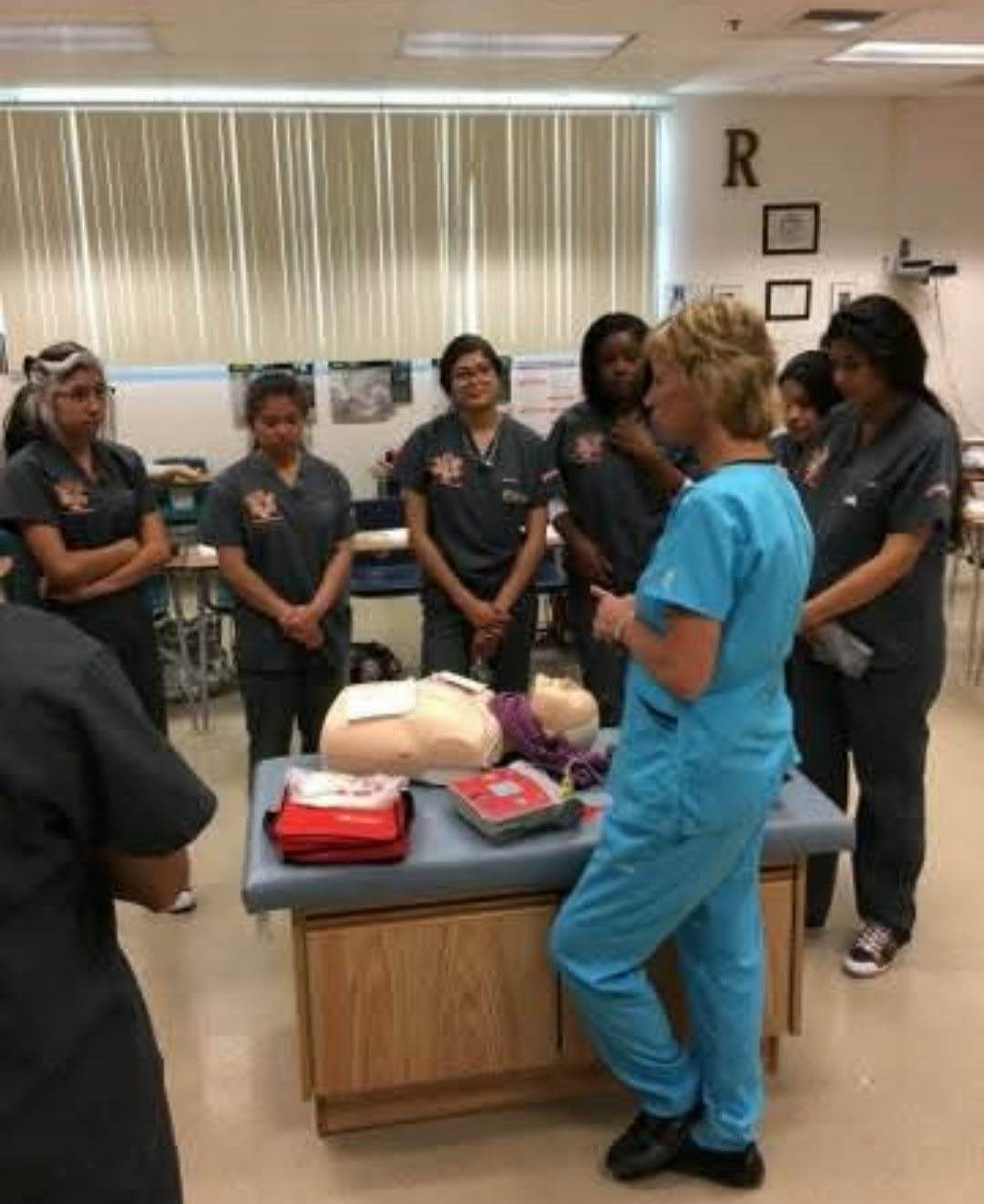 Instructor leading hands-on CPR and AED training for healthcare students